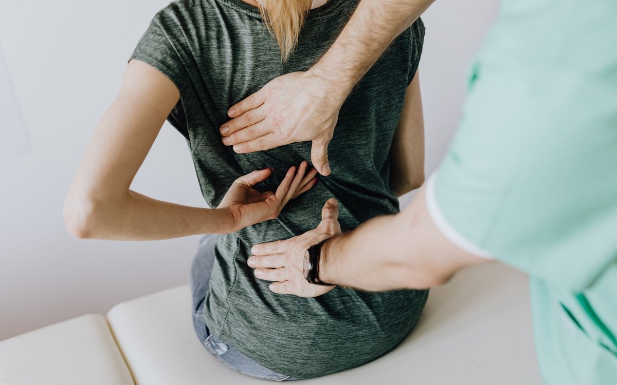 Physical therapist assessing low back pain